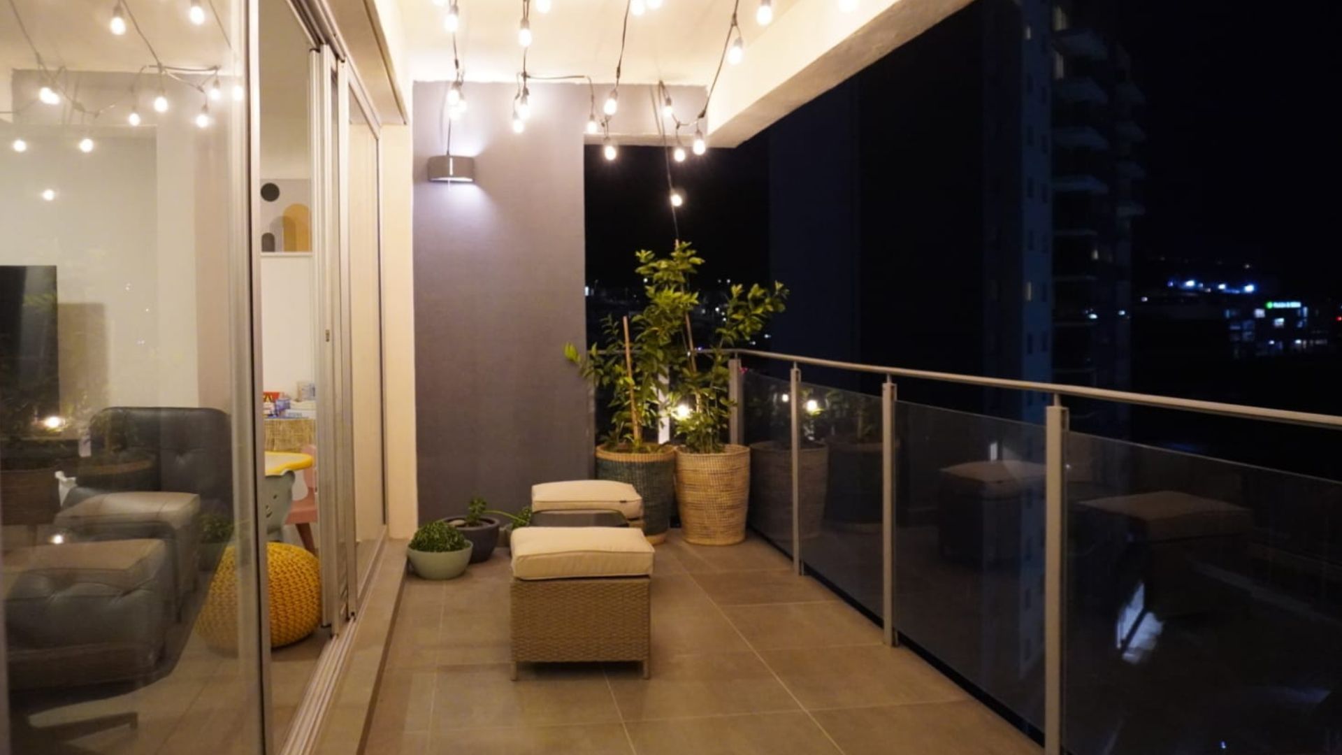 Terraza con luces colgantes, plantas y zona de descanso