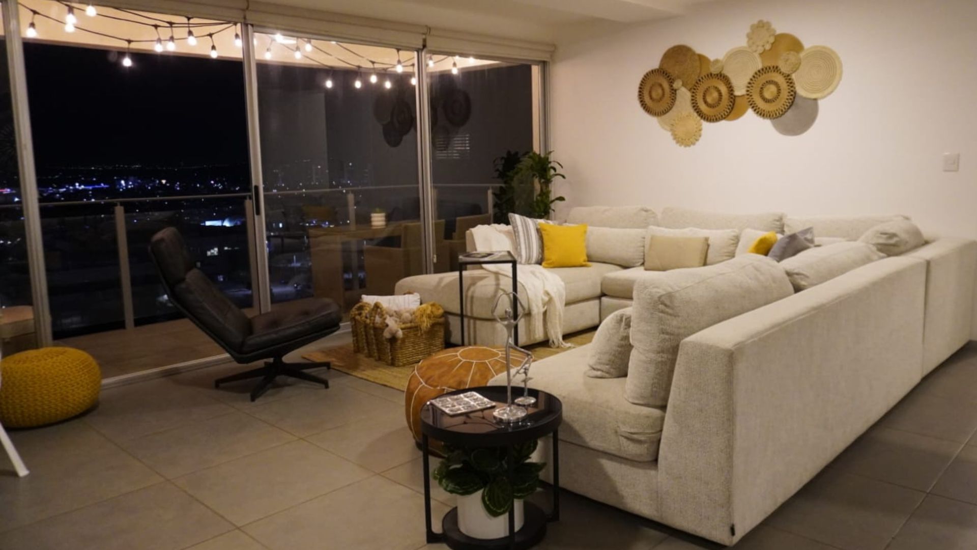 Sala con sofá familiar y vista nocturna a la ciudad